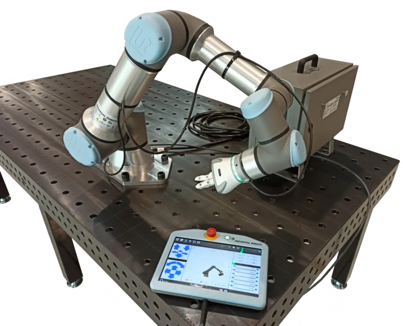 A collaborative robot arm on a workbench with its teach pendant